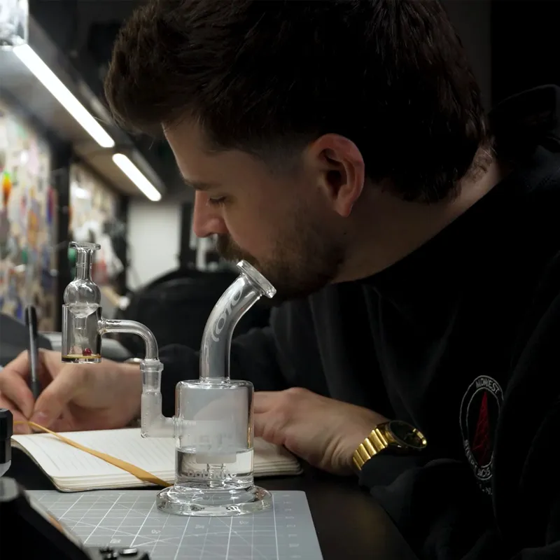 Maker examining a dab at a table